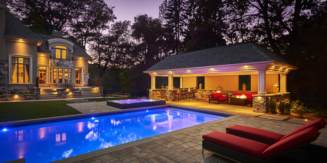 Exterior evening view of luxury home and pool